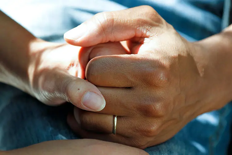 A close up of two people holding hands