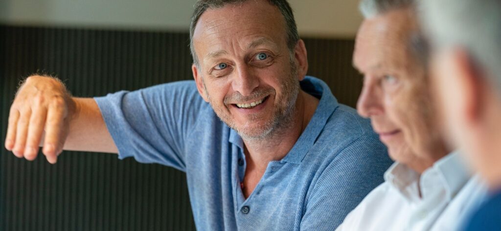 A man in blue shirt smiling at the camera.
